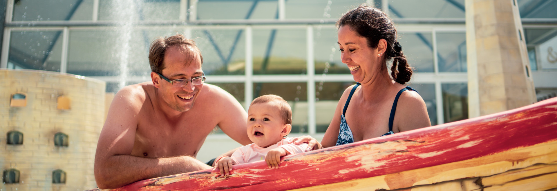 Holidays with baby | Couple with baby in paddling pool | First Holiday Offer for 3