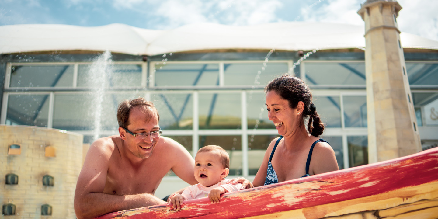 Vakantie met baby | Koppel met baby in pierenbadje | Eerste vakantieaanbieding voor 3